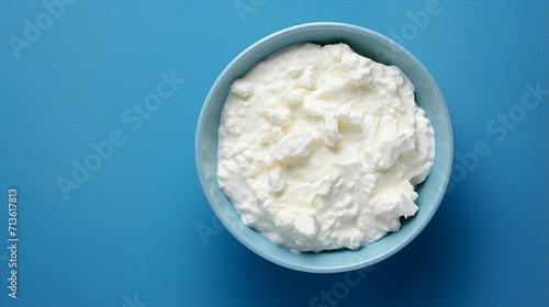 Cottage cheese in a bowl on a blue background, top view	 photo