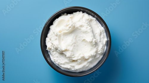 Cottage cheese in a bowl on a blue background, top view 