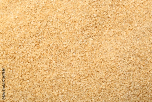 Granulated brown sugar as background, top view