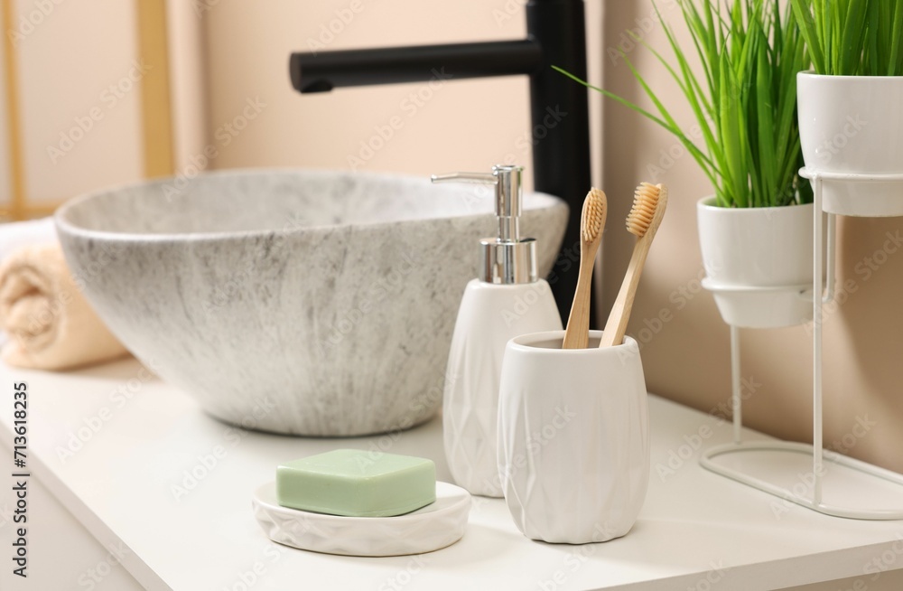 Different bath accessories and personal care products near sink on bathroom vanity Different bath accessories and personal care products near sink on bathroom vanity