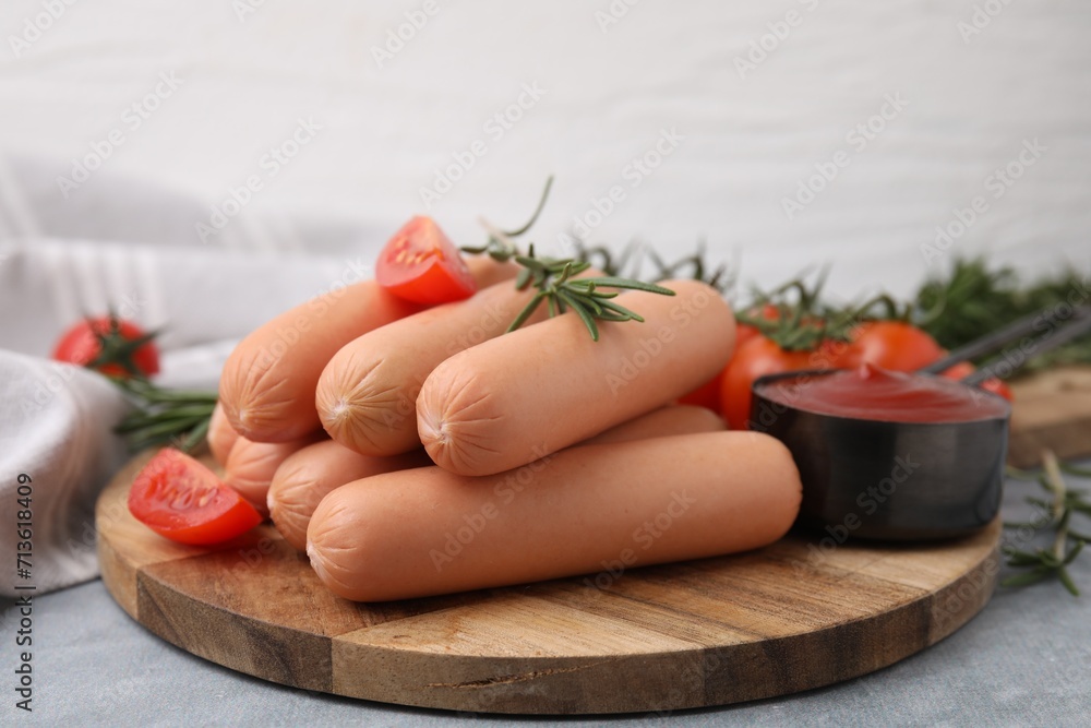 Delicious boiled sausages, tomato sauce, tomatoes and rosemary on gray table, closeup Delicious boiled sausages, tomato sauce, tomatoes and rosemary on gray table, closeup
