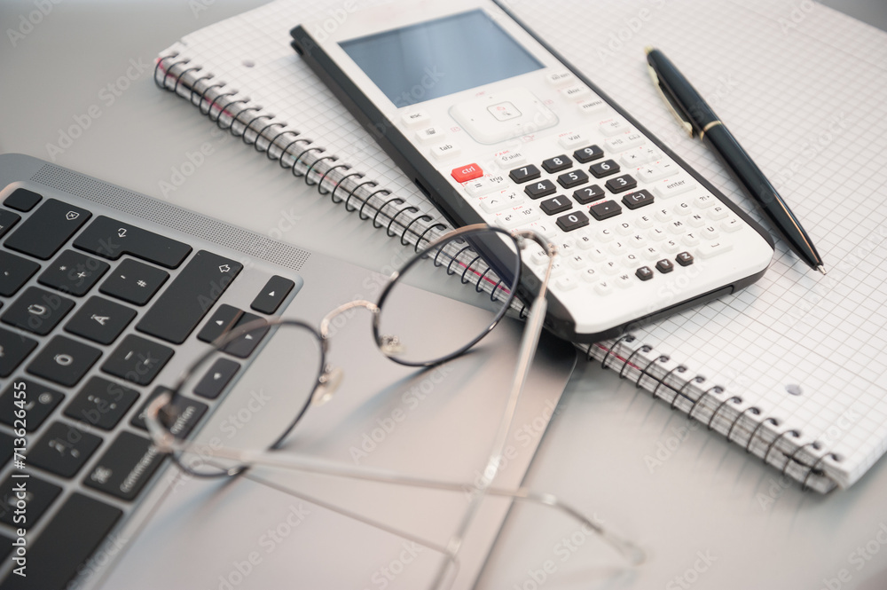 calculator laptop and glasses on a gray background calculator laptop and glasses on a gray background
