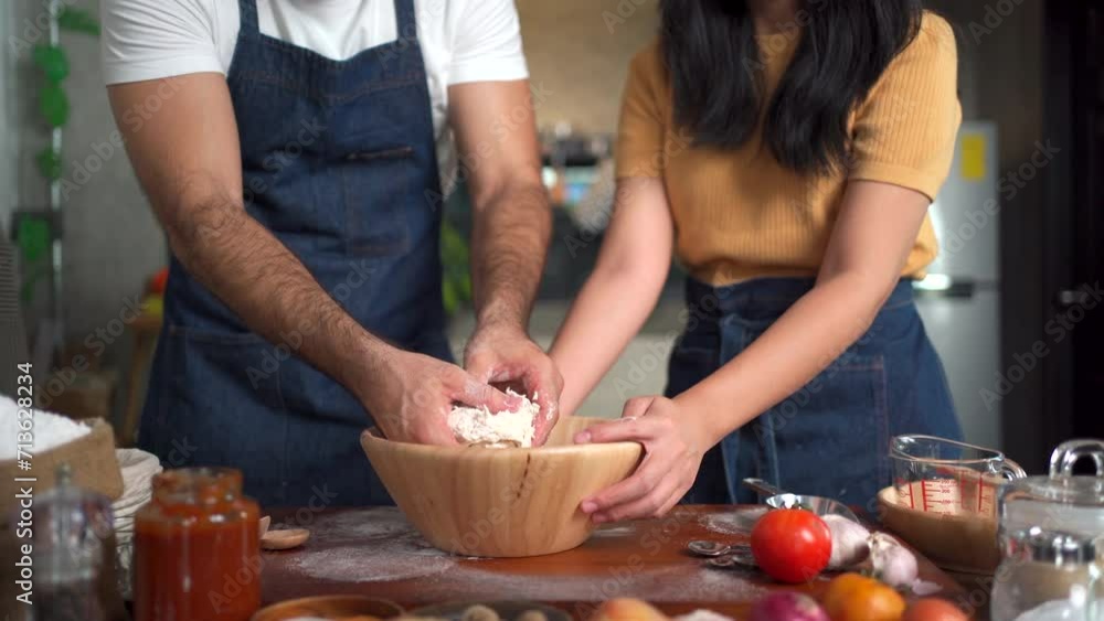Women and men knead dough together, creating a lively, aromatic atmosphere in the kitchen as they prepare to make pizza. Women and men knead dough together, creating a lively, aromatic atmosphere in the kitchen as they prepare to make pizza.
