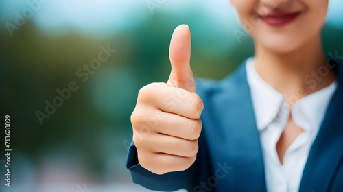 Close-up view of a woman's hand showing thumbs up as an expression of approval.