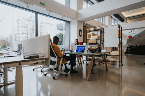Cuadro en lienzo Contemporary, spacious open-plan office with diverse employees focused on their tasks at individual workstations