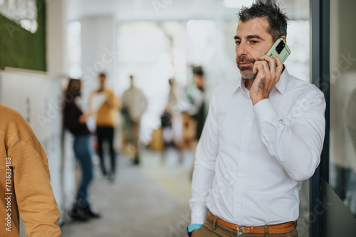 Successful middle-aged businessman negotiating a deal on a phone call in his office.