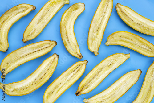 Yellow bananas cut in half on blue background
