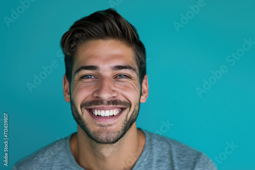 A man with a beard is smiling in front of a blue background © MagnusCort