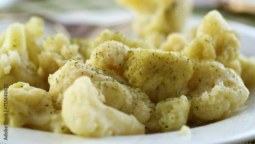 Cooked cauliflower, steamed, in a plate with spices . Cooked cauliflower, steamed, in a plate with spices .
