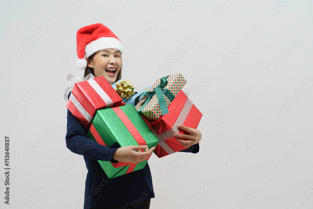 Asian woman young woman holding paper bag which has a lot of gift box on white background. Girl smiling, she is happy to get present for Christmas festival and happy new year's Asian woman young woman holding paper bag which has a lot of gift box on white background. Girl smiling, she is happy to get present for Christmas festival and happy new year's