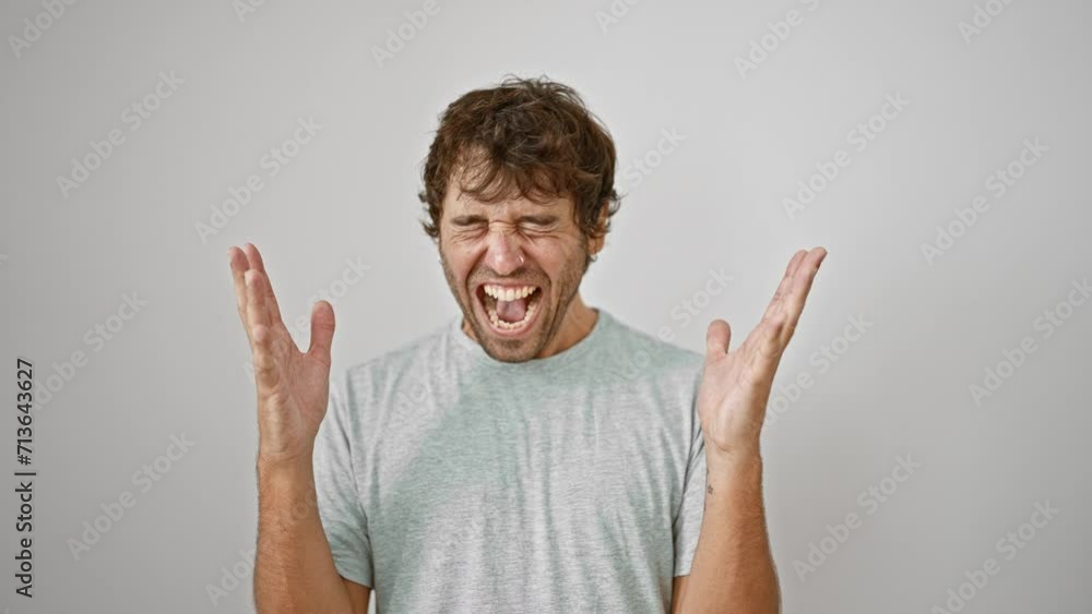 Excited young man celebrating crazy-mad success, arms raised in epic win, t-shirt-clad winner screams joy over isolated white background Excited young man celebrating crazy-mad success, arms raised in epic win, t-shirt-clad winner screams joy over isolated white background
