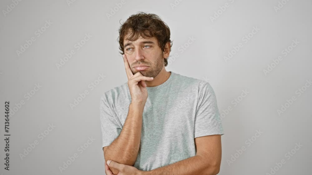 Young, bored-looking man in t-shirt, arms crossed, tired from battling depression, lost in thought over white isolated background. Young, bored-looking man in t-shirt, arms crossed, tired from battling depression, lost in thought over white isolated background.