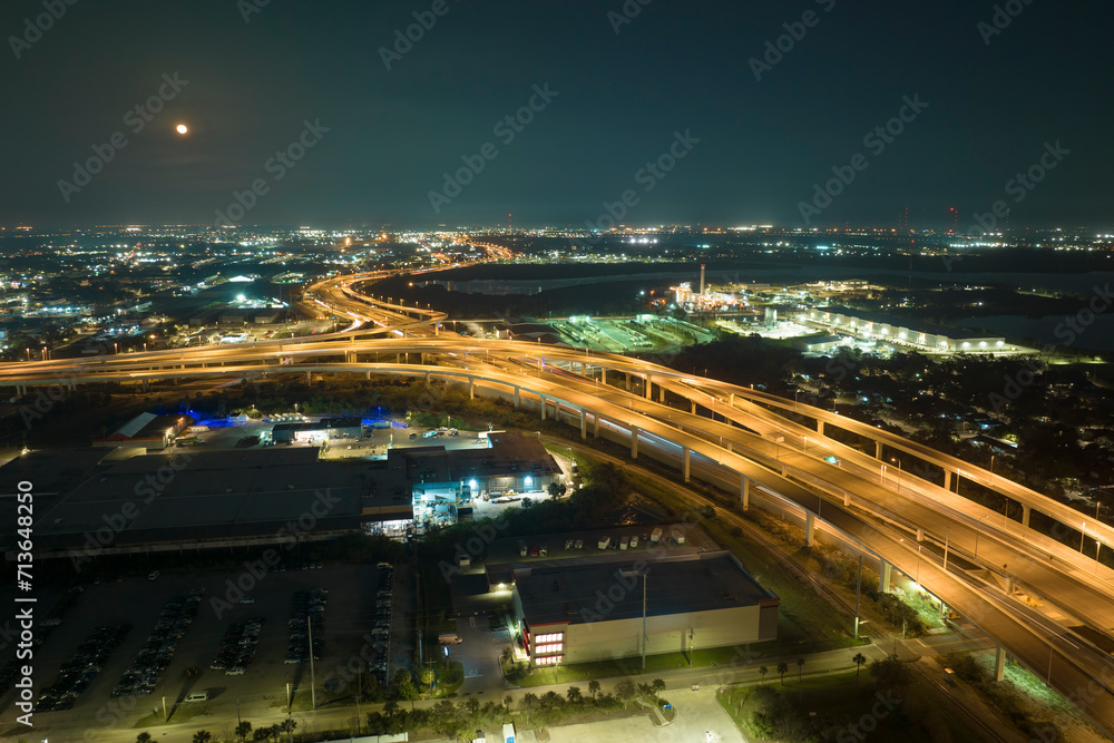 View from above of american big freeway intersection in Tampa, Florida at night with fast moving cars and trucks. USA transportation infrastructure concept