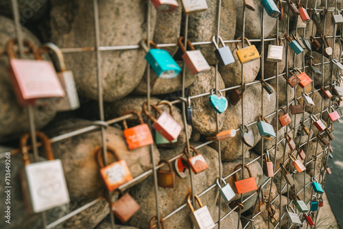 Bild auf Leinwand Metal locks on a grid with stones on the promenade by the sea