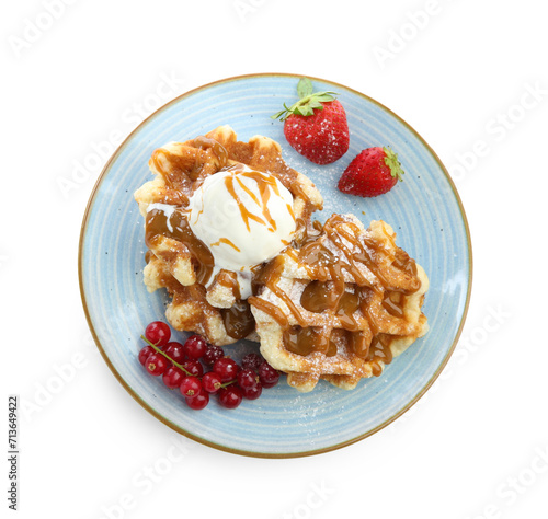 Tasty Belgian waffles with ice cream, berries and caramel syrup on white background, top view
