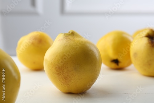 Tasty ripe quinces on white wooden table, closeup