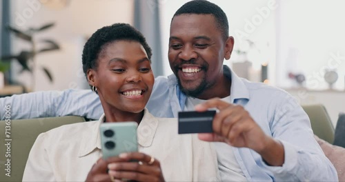 Couple, phone and credit card on sofa, home living room and happy for discount, sale or savings with fintech. African man, black woman and smartphone for digital banking, deal or e commerce on couch photo