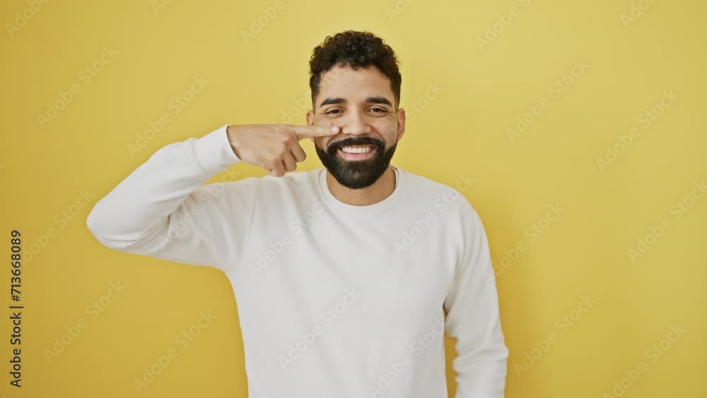 Cheerful young man, radiating beauty, standing isolated on yellow background, finger-pointing to his healthy skin nose, smiling bright! Cheerful young man, radiating beauty, standing isolated on yellow background, finger-pointing to his healthy skin nose, smiling bright!