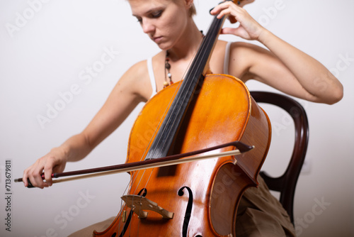 A young woman playing cello on the concert at night.