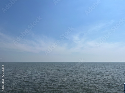 A photograph of a horizon with a blue sky and a dark sea. © kiart666