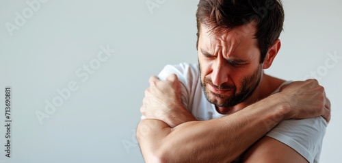 Digitally generated image of man suffering with shoulder inflamation. Guy holding hand to shoulder of aches photo