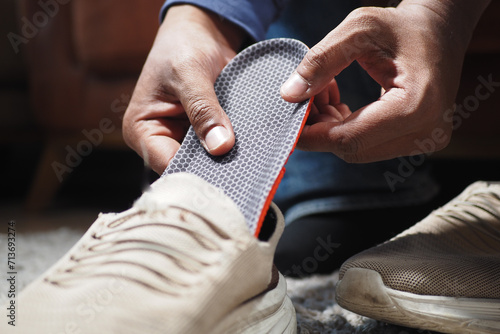 men hand putting Orthopedic insoles in shoes  photo