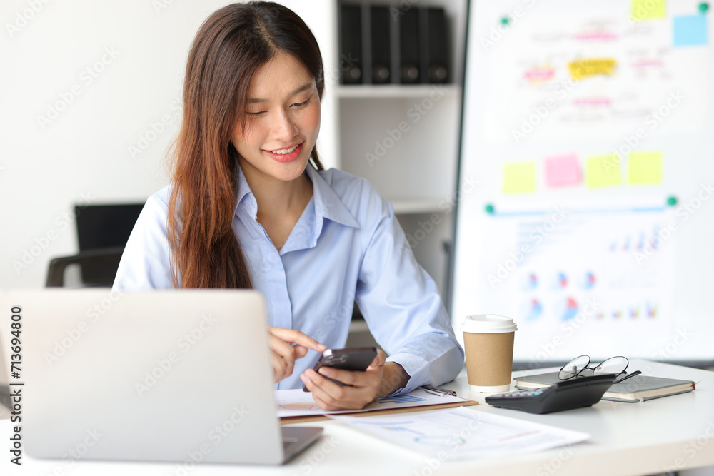 Asian woman in office is using mobile phone and calling someone, she is smiling with joy and surprise when receiving good news. Asian woman in office is using mobile phone and calling someone, she is smiling with joy and surprise when receiving good news.