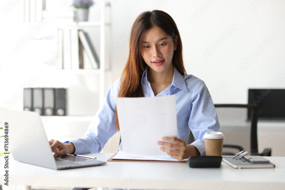 Portrait of attractive Asian businesswoman working with laptop and documents in office. Portrait of attractive Asian businesswoman working with laptop and documents in office.
