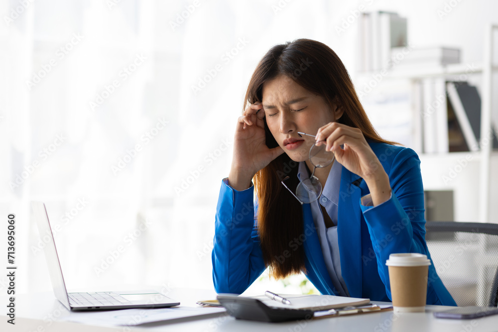 Asian businesswoman is stressed and has a headache from overwork. Asian businesswoman is stressed and has a headache from overwork.