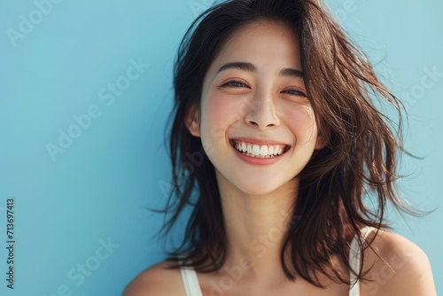 Serenely smiling Asian woman, natural demeanor, blue background