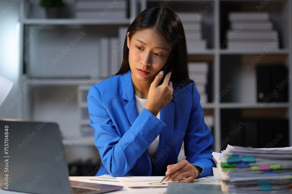 Stressed and tired Asian young businesswoman feels headache while working overtime at night in office. Stressed and tired Asian young businesswoman feels headache while working overtime at night in office.