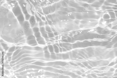 White water with ripples on the surface. Defocus blurred transparent white colored clear calm water surface texture with splashes and bubbles. Water waves with shining pattern texture background.