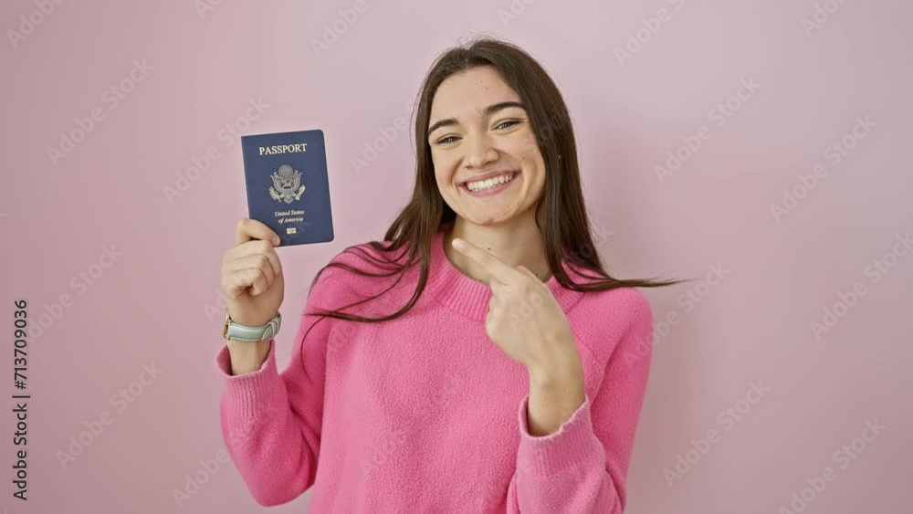 Excited young hispanic woman proudly showing off her usa passport! smiling, finger pointing over isolated pink background - confident, happy, and hopeful. Excited young hispanic woman proudly showing off her usa passport! smiling, finger pointing over isolated pink background - confident, happy, and hopeful.