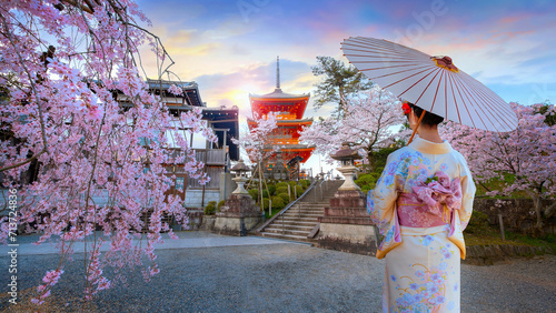Young Japanese women in a traditional Kimono dress at Kiyomizu-dera temple sunrise during full bloom cherry blossom in Kyoto, Japan photo