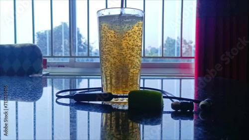 fresh lemonade chia seed honey juice on a table with headphone at winter morning infront of a open window.  photo
