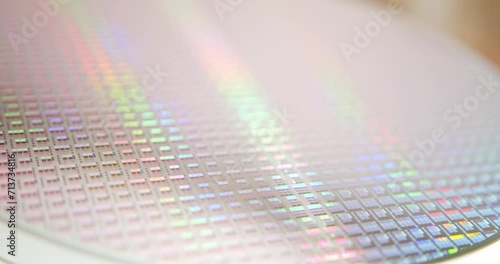 A close-up view of a silicon wafer's microprocessor circuit layout. The semiconductors or central processing unit CPU microchips are fabricated from a silicon wafer with patterned layers of materials. photo