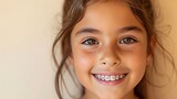 Indian beautiful little girl in braces smiles happily. Taking care of dental health, oral hygiene. Advertising for pediatric dentistry