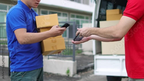 Man uses mobile phone to confirm payment before picking up parcel from deliveryman. Customer handwriting on phone to pick up package from postman. photo