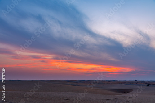 Beautiful dramatic clouds sunset sunrise over the desert sand dune of Abu Dhabi, UAE