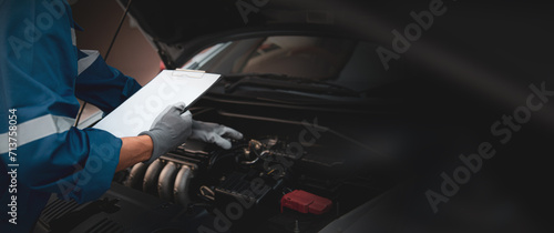 Hand auto mechanic checking inspection list after fix or repairing change spare part engine problem with car care maintenance servicing icons for insurance service support or the range of car check.