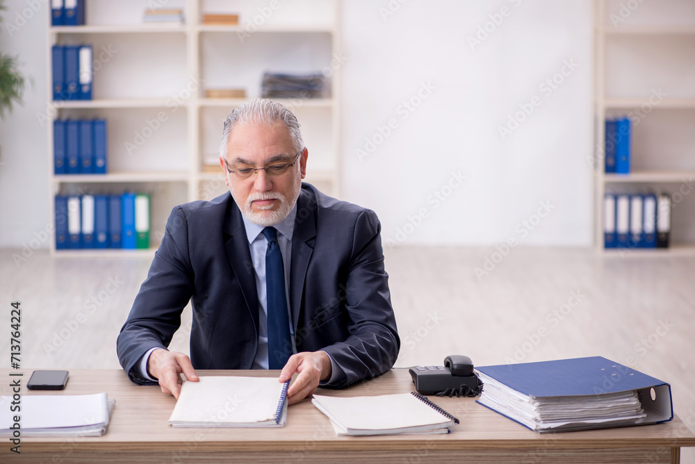 Old male employee working in the office Old male employee working in the office