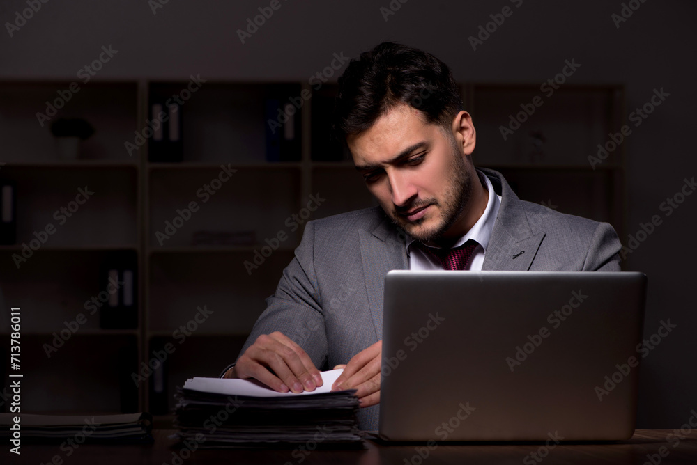 Young male employee working late in the office Young male employee working late in the office