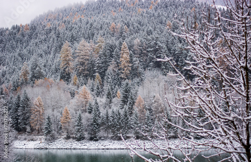 It's snowing on the lake in the forest high in the mountains © corradobarattaphotos