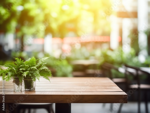 Modern cozy outdoor restaurant with green plants  blurred background with wooden table for product and text placement