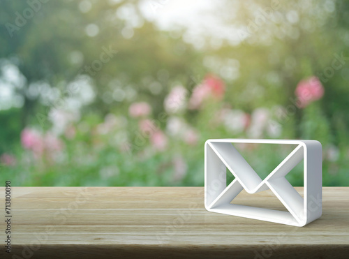 Mail 3d icon on wooden table over blur pink flower and tree in garden, Business customer service and support online concept