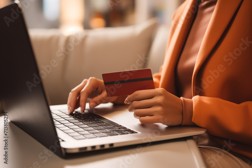 Woman using laptop with credit card for payment online