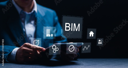 BIM or Building information modeling technology concept. Businessman using tablet with virtual BIM icons.