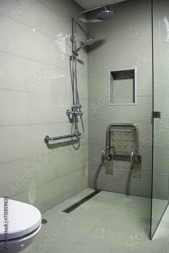 Accessible shower with a chair, promoting inclusion in hotels. Comfort and accessibility for all guests