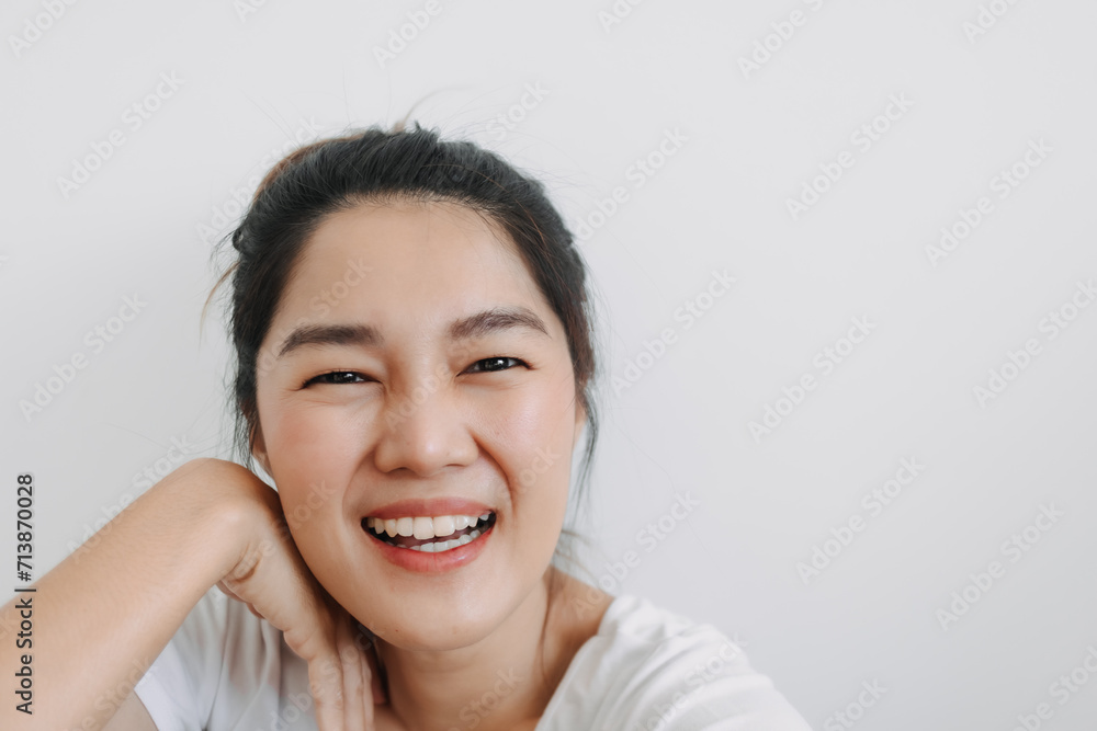 Happy asian Thai woman take selfie and smiling to camera, resting head on hand posting, isolated over white background wall Happy asian Thai woman take selfie and smiling to camera, resting head on hand posting, isolated over white background wall