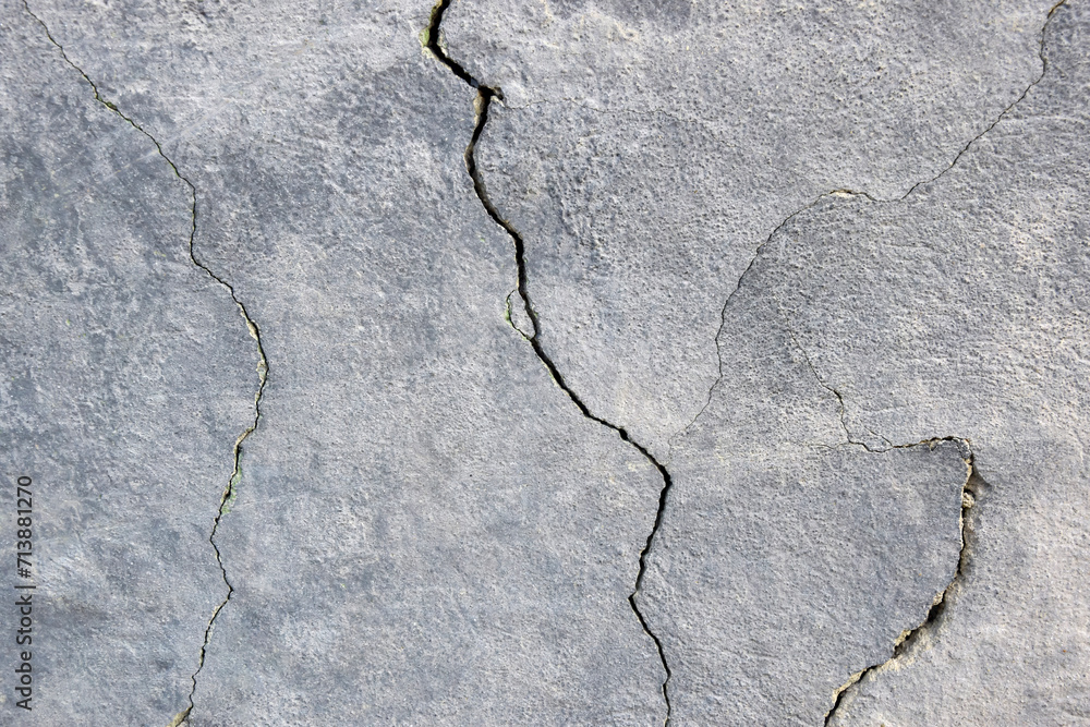 Obraz premium The wall of an old building with many winding, deep cracks. Copy space. Selective focus.